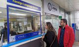 Aline Busicchia uit Sydney communiceert via het vertaalscherm met een medewerker van het metrobedrijf op  station Myeongdong in Seoul. 