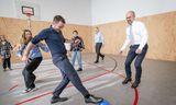 De ambassadeur van Oekraïne, Oleksandr Karasevych (rechts) en de Bredase wethouder onderwijs Arjen van Drunen (links) voetballen met leerlingen tijdens een bezoek aan de Oekraïense school in Breda.   