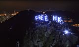 „Free HK.” Tijdens een protest vorig jaar in Hongkong houden demonstranten neonletters omhoog met die boodschap.