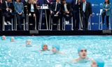 Macron bij de inauguratie van het olympisch zwembad. Helemaal rechts de burgemeester van Parijs, Anne Hidalgo.