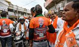 Partijmedewerkers van de BJP verzamelen zich buiten bij het kantoor in Vadnagar voor een campagne-bijeenkomst.