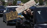 Bij een protestbijeenkomst vorige maand om de vrijlating te eisen van in Rusland gevangengehouden Azov-strijders zetten betogers hun eisen kracht bij met op karton geschreven slogans. Foto SERGEY DOLZHENKO / EPA  