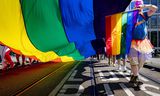 Deelnemers aan de Pride Walk lopen door het centrum van Amsterdam.