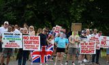 Demonstranten, onder wie iemand met een masker van premier Keir Starmer, bij een protest bij een hotel in Aldershot waar asielzoekers zijn ondergebracht.