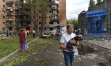 Bewoners van een flatgebouw dat is beschadigd bij Oekraïense beschietingen verlaten zondag hun woningen in het Russische Koersk. 