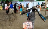 Ontheemde Soedanezen uit de plaats Sinjah ontvangen donderdag humanitaire hulp in een tijdelijk kamp in de oostelijke stad Gedaref.  