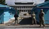 Een Zuid-Koreaanse soldaat (links) en VN-militairen (rechts) staan in oktober 2022 op wacht bij de blauwe huisjes in Panmunjom, aan de grens tussen Noord- en Zuid-Korea.  