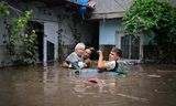 Buurtbewoners redden zaterdag een oudere  in het Roemeense dorp Slobozia Conachi bij overstromingen als gevolg van storm Boris. 