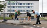 Maandag: Mensen helpen met opruimen van de rommel voor het Holiday Inn Express hotel in Rotherham na de rellen zondag. 