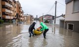 In een opblaasbare kayak brengen  inwoners van Cesena buurtgenoten naar droger terrein.