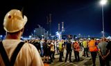 Havenmedewerkers tijdens een werkonderbreking in de haven van Rotterdam op zaterdagavond. 