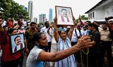 Pro-regeringsdemonstranten met portretten van premier Mahinda Rajapaksa betogen maandag bij de ambtswoning van de premier in  Colombo.