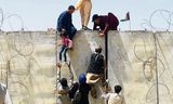 Afghanen vluchten naar het vliegveld van Kaboel. 