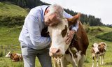 Harm Holman van NSC, oud-melkveehouder, knuffelt een koe.