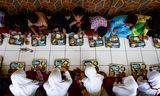 Studenten eten de gratis lunchmaaltijd. Foto Willy Kurniawan/Reuters 