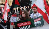 ‘Verenigd voor vrede’ staat op de borden van deelnemers aan een mars in Sofia op 21 oktober, georganiseerd door de pro-Russische partij Revival. Met de mars demonstreerde Revival tegen de Israëlische aanvallen op Gaza en Libanon.   