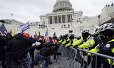 Aanhangers van president Donald Trump proberen door een politiebarricade te breken bij het Capitool in Washington. Duizenden van hen verzamelden zich in de Amerikaanse hoofdstad om Trumps ongefundeerde beweringen over verkiezingsfraude te steunen.