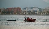 Een boot van het Spaanse Rode Kruis sleept een bootje waar twintig Marokkaanse migranten mee zijn overgestoken naar Malaga. 