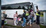 Vluchtelingen wachten op de pendelbus naar Emmen, vlakbij bij het aanmeldcentrum van de IND in Ter Apel. 