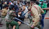 Keniaanse politieagenten arresteren activisten voor het kantoor van de president in Nairobi. Foto Simon Maina / AFP 