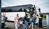 Asielzoekers bij de pendelbus naar Emmen, vlak bij het aanmeldcentrum in Ter Apel. Foto Kees van de Veen