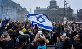 Supporters van Maccabi Tel Aviv en Ajax met een Israëlische vlag op de Dam. In aanloop naar de wedstrijd Ajax - Maccabi Tel Aviv donderdagavond zijn een aantal delen van Amsterdam aangewezen als veiligheidsrisicogebied.