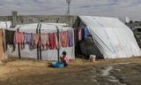 Een ontheemd Palestijns meisje wast woensdag kleren bij een tent in Deir al-Balah in de centrale Gazastrook. 