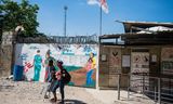 Een man op krukken en een vrouw verlaten een kliniek van Artsen zonder Grenzen in Port-au-Prince nadat ze vernomen hebben dat de hulporganisatie de activiteiten heeft opgeschort. 