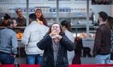Patricia Oppelaar (46) uit Reeuwijk hapt voor de eerste keer in een Dubai-oliebol, bij de oliebollenkraam in Zevenhuizen. Haar dochters hadden ’m op Tiktok gezien.