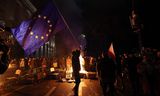 Een demonstrant houdt een EU-vlag vast vlak bij het Georgische parlement.