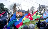 Activisten in Den Haag volgen buiten de livestream van de door Vanuatu aangespannen klimaatzaak. 