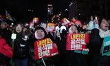 Demonstranten houden zaterdag in Seoul spandoeken vast waarin wordt opgeroepen tot de afzetting van de Zuid-Koreaanse president Yoon Suk-yeol. 