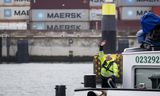 Een schipper op een containerschip bij de APM Terminal op de Rotterdamse Maasvlakte. Omdat de handel met de VS maar een klein deel omvat van de voor Nederland relevante handel, zullen de gevolgen van de Amerikaanse tariefsverhogingen beperkt zijn. 