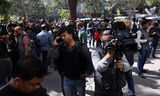 Journalisten staan in februari in New Delhi buiten bij de BBC-redactie terwijl Indiase belastingambtenaren  een huiszoeking uitvoeren.