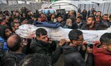 KHAN YUNIS, GAZA - JANUARY 16: Relatives of Ahmad Al-Shayah, a journalist killed in Israeli drone attack on a charity facility, carry his shrouded body which they laid a blue press vest on, at Nasser Hospital in Khan Yunis, Gaza on January 16, 2025.