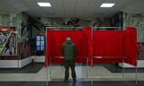 Een Wit-Russische militair maakte donderdag op een stembureau op zijn legerbasis in Minsk gebruik van de mogelijkheid vervroegd te stemmen. Foto Natalia Kolesnikova / AFP 