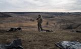 Oekraïense vrijwilligers onderzoeken de persoonlijke bezittingen van gesneuvelde Russische soldaten op het slagveld in de regio Donetsk. 