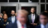 Donald Trump Jr. (links) and Eric Trump luisteren naar hun vader terwijl die eind mei met de pers praat tijdens een rechtszitting in New York. Met hun jongste broer Barron vormen de twee de drijvende krachten achter het toekomstige cryptoplatform World Liberty Financial.  