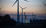 Windmolens in de Eemshaven, op de achtergrond een datacentrum en een groot schip met een kraan. 