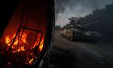 Oekraïense tank passeert een brandende auto in de regio Soemy, bij de grens met Rusland. Foto Evgeniy Malotletka/AP   