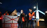 Activisten Karin Pierik (midden) en Chiel Stemerdink, met rechts een demonstrant op stelten, uitgedost als een windmolen. 