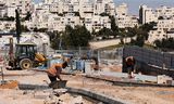 Palestijnse arbeiders werken in de Israëlische nederzetting Maale Adumim op de Westelijke Jordaanoever. De Israëlische bouwsector is deels stil komen te liggen.  Foto Menahem Kahana/AFP