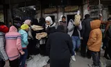 Mensen staan ​​in Douma, een voorstad van Damascus, in de rij om brood te kopen, nadat  Bashar al-Assad uit Syrië is verdreven. 