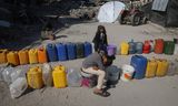 Palestijnse kinderen wachten bij een rij jerrycans en emmers om water te halen, in Beit Lahia, in het noorden van de Gazastrook, op 29 januari. Foto Jehad Alshrafi / AP 