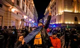 Een vrouw protesteert maandag in Boekarest bij een blokkade van de oproerpolitie, na botsingen met aanhangers van de Roemeense presidentskandidaat Calin Georgescu wegens diens uitsluiting van de verkiezingen. 