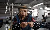 Medewerker in een textielfabriek in  Shaoxing, in de provincie Zhejiang in Oost-China. De export van China naar de VS is in april met 21 procent gekelderd, maar dat wordt ruimschoots goedgemaakt door een flinke stijging van de export naar andere Aziatische landen en naar Europa. Foto Greg Baker/AFP 