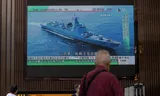 Beelden van een Chinees marineschip op een scherm in een winkelcentrum in Hongkong na het omstreden bezoek van Nancy Pelosi, voorzitter van het Amerikaanse Huis van Afgevaardigden, aan Taiwan. China heeft aangekondigd de komende dagen militaire oefeningen rond het eiland te houden. 