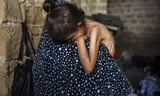 Een moeder draagt haar uitgehongerde en zeer verzwakte dochter (zes jaar) op de arm. In het zuiden van Gaza voltrekt zich, net als in andere delen van het gebied, al maanden een humanitaire ramp.   
