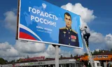 Een billboard met reclame voor het Russische leger in Lenino, ten westen van Moskou. Naast de foto van Luitenant Joeri Kotsitj staat de tekst: 'Trots van Rusland' credit: Foto Getty Images 