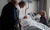 De arts Yves de Locht (links) en hoogleraar palliatieve zorg Wim Distelmans, op 1 februari 2024, in een Belgisch ziekenhuis waar de Française Lydie Imhoff (midden) euthanasie wordt verleend. Zorgverlener Marie-Josee Rousseaux houdt haar hand vast. Fotograaf Simon Wohlfahrt maakte een fotoserie over de aan Lydie Imhoff verleende euthanasie. 